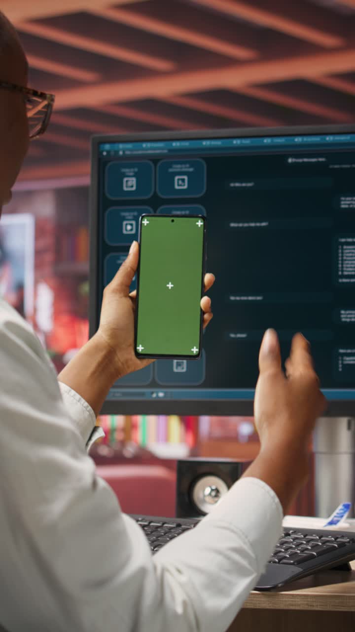 Vertical video Woman seated at desk using AI LLM chatbot software and green screen phone