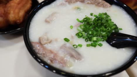 초록 양파 와 함께 전통적 인 콘지 를 맛보는 것