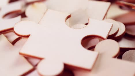 Closeup-of-Jigsaw-Puzzle-pieces-placed-on-a-turning-table-revealing-pieces-exposed-to-light-and-creating-shadows.