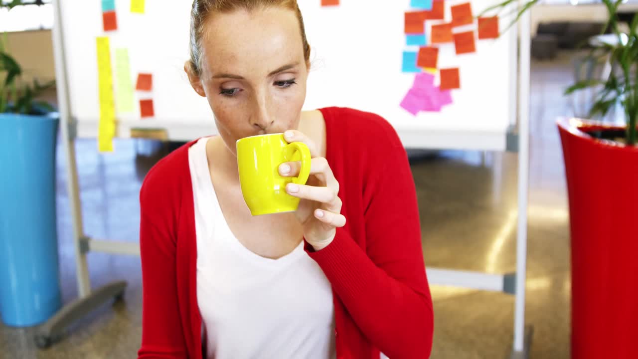 Executive having coffee while working in the office