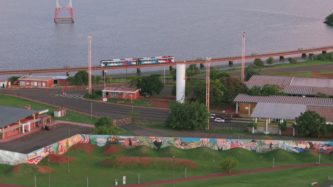 Transportation bridge near the Paraná river with buildings and local customs with murals on a panoramic shot from above, Posadas, Misiones, Argentina.