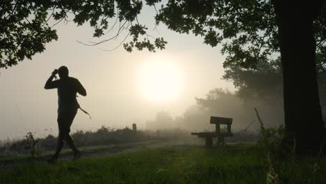 hiker walking through a misty morning landscape at sunrise
