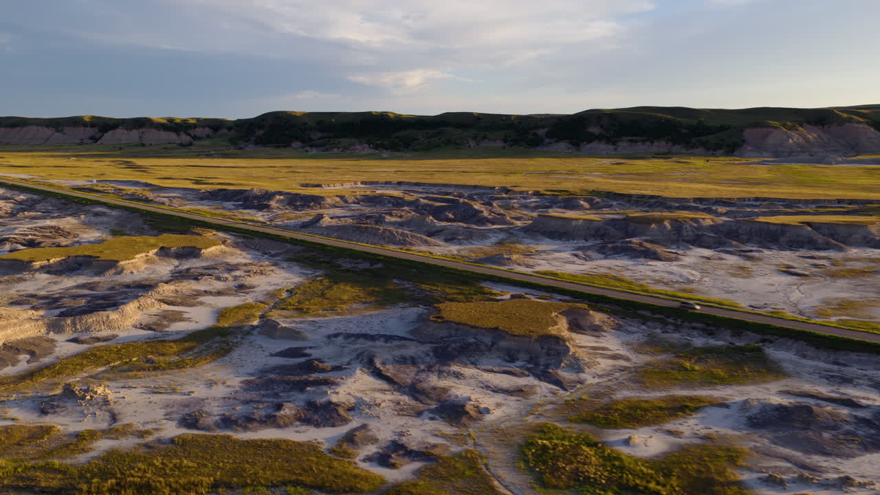 Sunset Colors Glow Over Badlands Road in Breathtaking Drone Flight