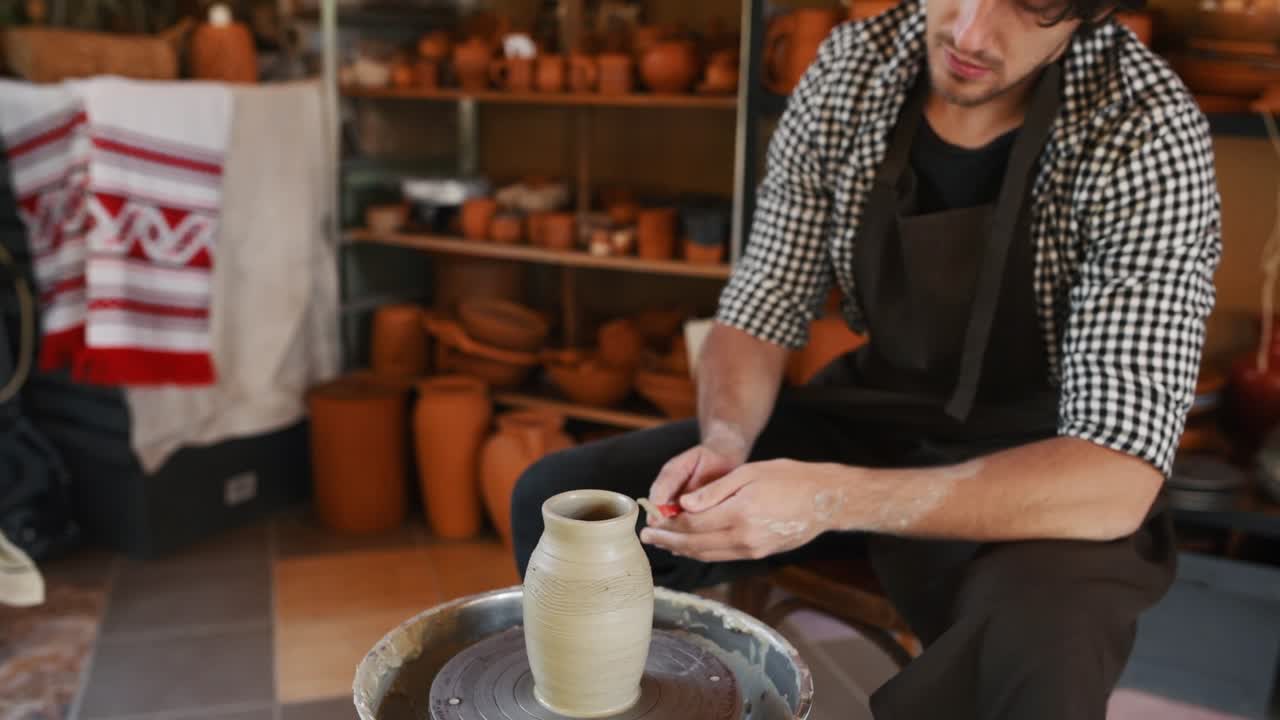 Il ceramista utilizza un attrezzo speciale sul tornio da vasaio e realizza un manufatto in argilla