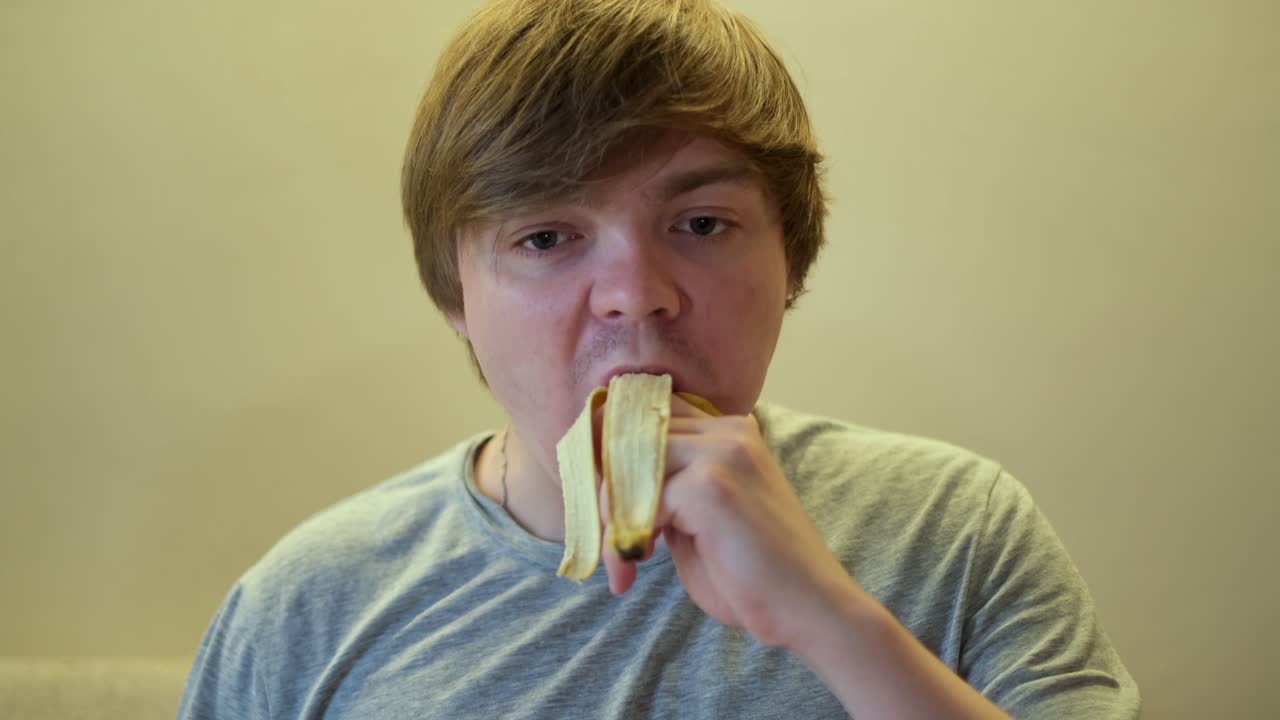 Giovane uomo che mangia una banana