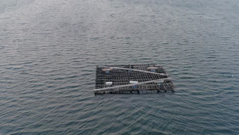 Simple-mussel-farming-batea,-dynamic-drone-shot