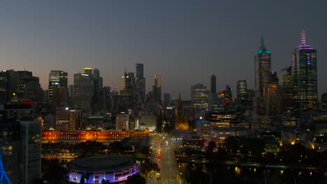 dusk tracking aerial perspective moving down st kilda road toward melbourne art spire and flinders street station