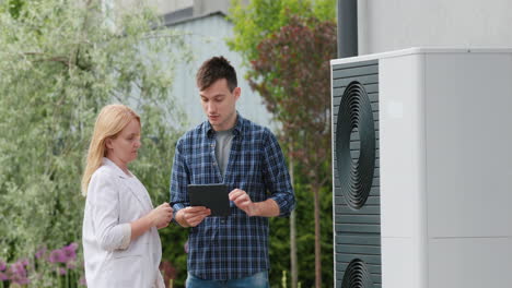 a young engineer advises a client in setting up a heat pump