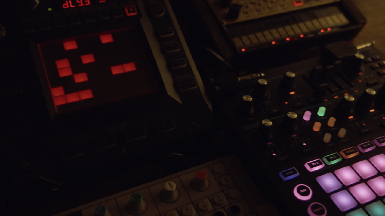 Mano che suona pad di sintetizzatore di musica elettronica in uno studio buio