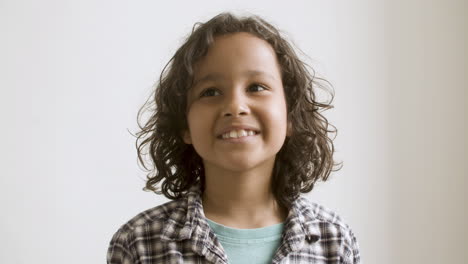 young curly-haired boy smiling at camera.