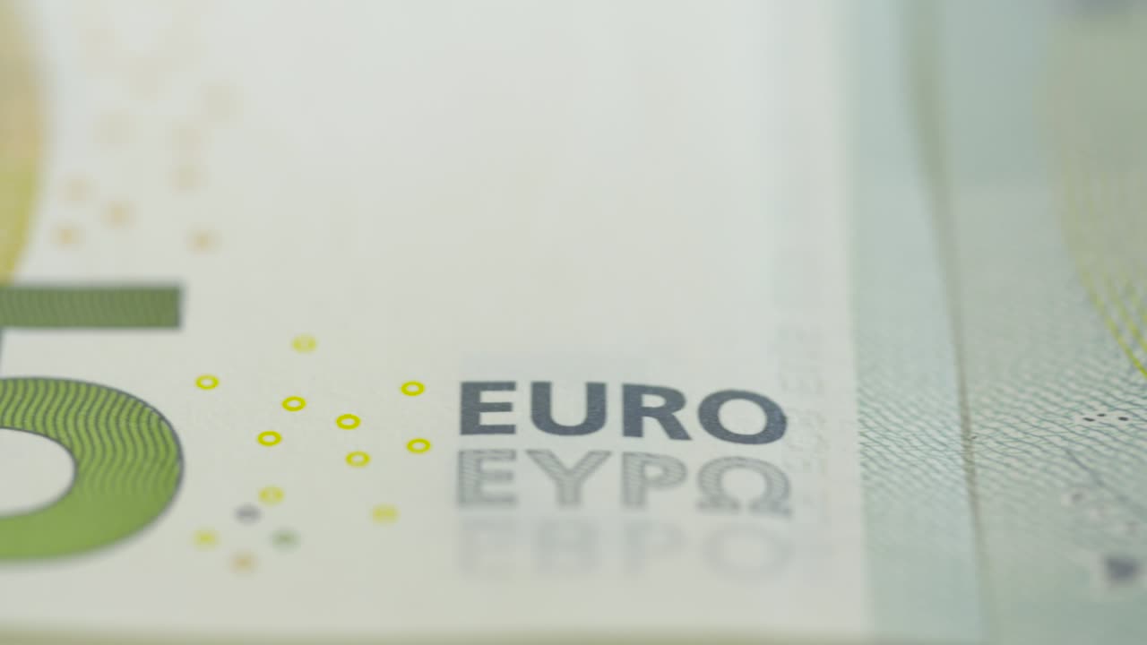 가혹하게 조명된 5유로 지폐를 가로질러 추적