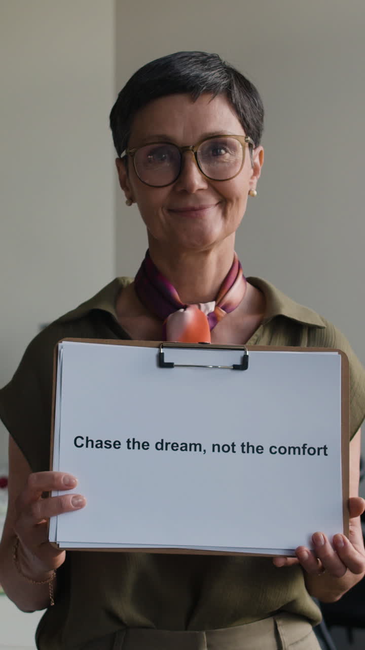 A woman holding a sign with a motivational quote about chasing dreams