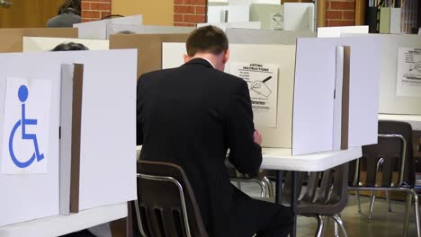 スーツを着て政治選挙の票を投じている男の頭の背中