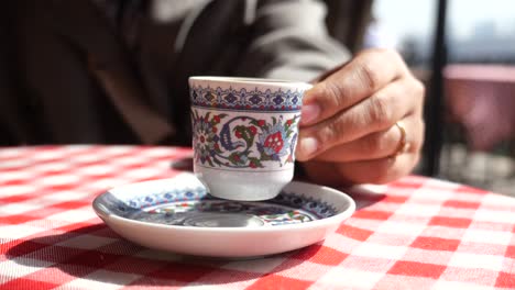 una persona sosteniendo una taza de café turco en una cafetería