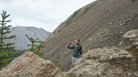 hiker taking photos in the mountains crab rockies kananaskis alberta canada