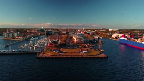 a drone shot starting over the water flying down a small harbor main street