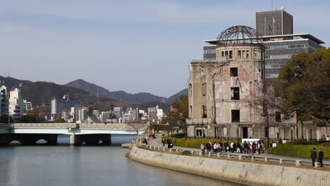 visitantes explorando ruinas históricas cerca de una vía fluvial tranquila