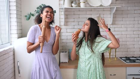 two friends singing and dancing in a kitchen