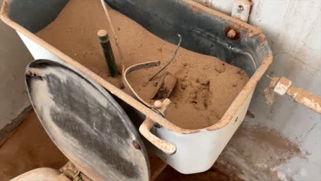 Comical-scene-of-a-toilet-filled-with-sand-in-an-abandoned-house-in-the-famous-ghost-town-of-Kolmannskuppe-Namibia