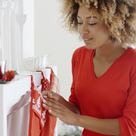 Happy-young-woman-hanging-Christmas-stockings