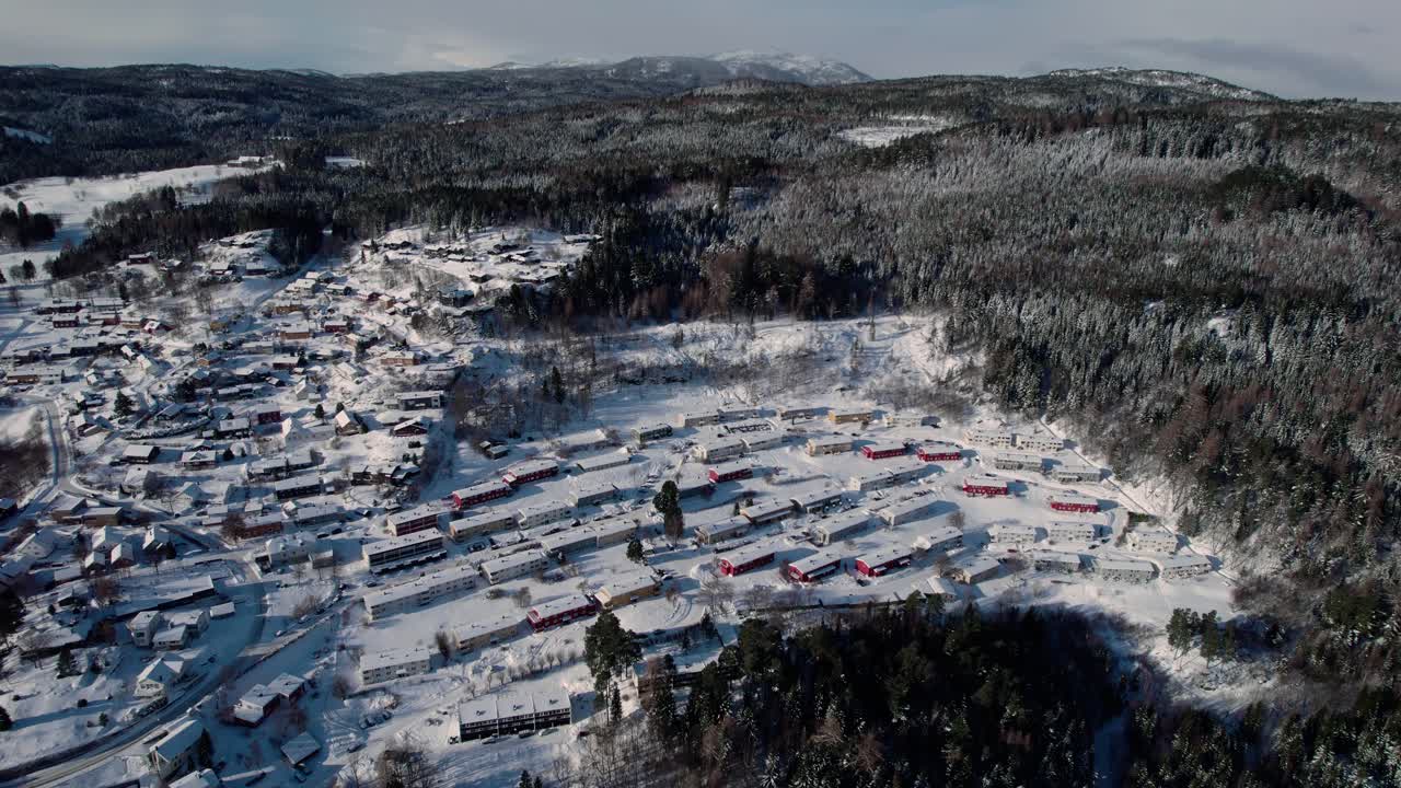 trondheim, noruega, avión no tripulado hacia adelante descendiendo disparado sobre las casas de la ciudad cubiertas de nieve blanca gruesa en un día frío de invierno