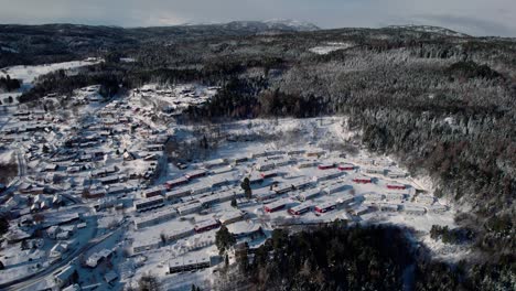 Trondheim,-Norway,-Aerial-drone-forward-descending-shot-over-city-houses-covered-with-thick-white-snow-on-a-cold-winter-day