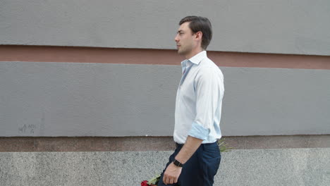 closeup businessman going on date with roses. man walking with beautiful flowers