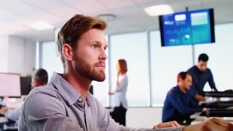 Male-executive-talking-on-telephone-while-working-at-desk