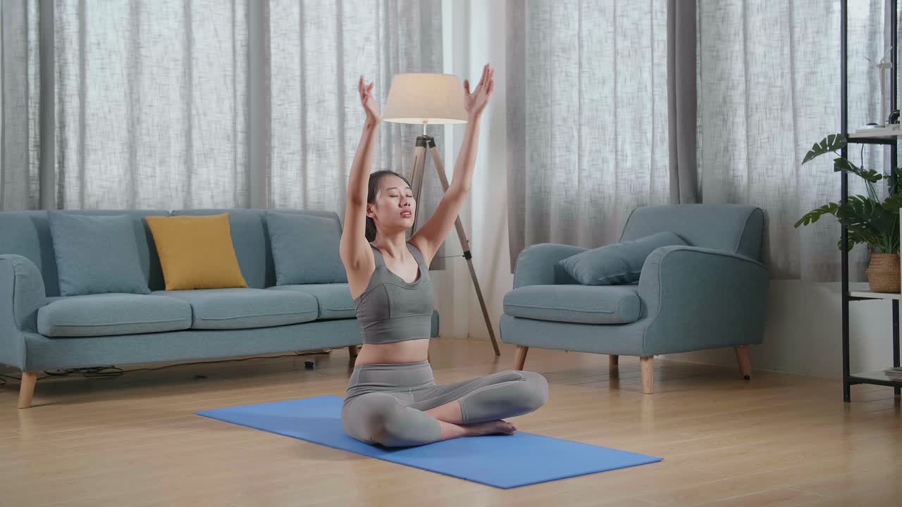 젊은 아시아 운동선수 여성은 요가 매트에서 운동하는 동안 수카사나 포즈로 요가를합니다. 건강한 생활 방식, 피트니스, 웰빙 및 마인드풀니스