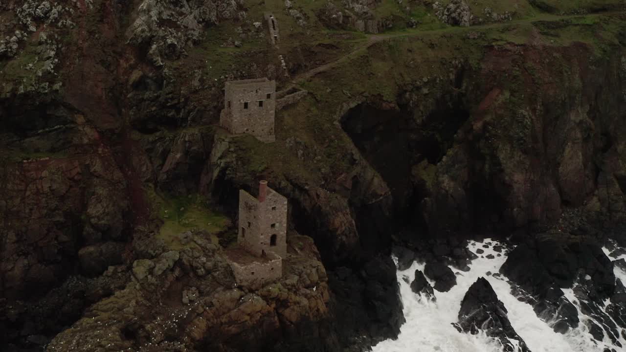Aerial orbit around the pump house of the tin mines where the Atlantic meets the stone Cornwall coast.