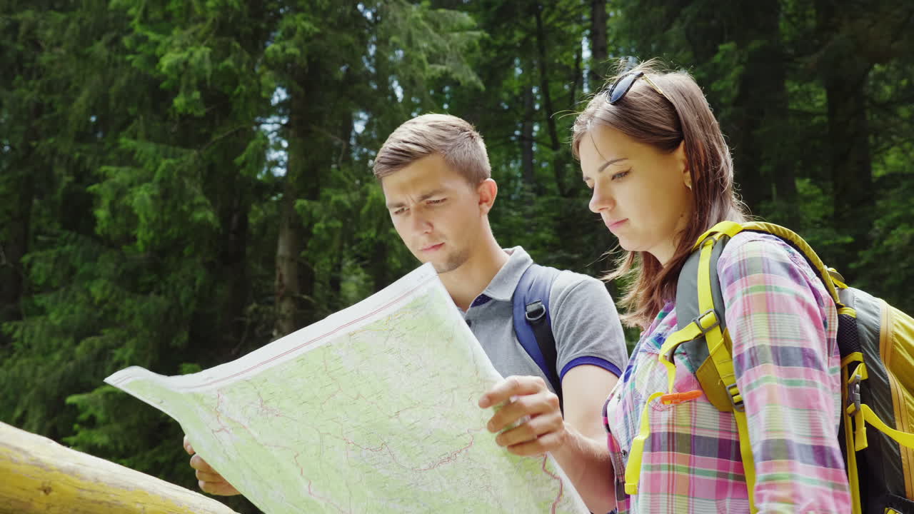 turismo y estilo de vida activo una pareja joven mira el puesto de mapas en un lugar pintoresco en un verano