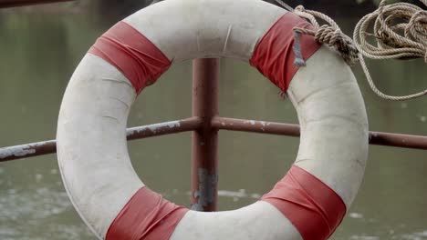 an establishing shot of a lifesaving buoy positioned on the corner of a river raft, a safety precaution should anyone fall into the fast flowing river water in kanchanaburi, thailand