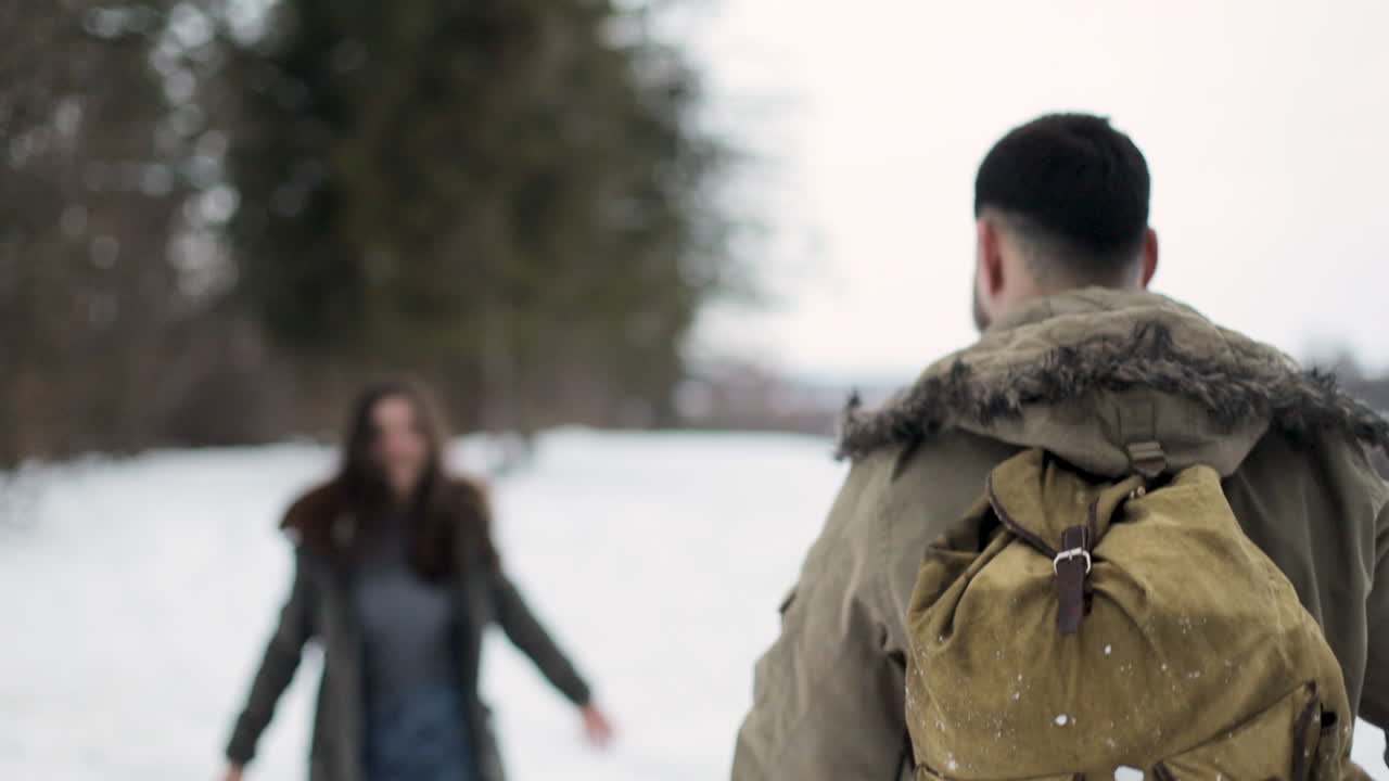 pareja caucásica caminando en un bosque nevado.