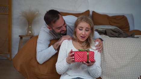 Mujer-Joven-Recibe-Regalo-De-Navidad-En-Casa