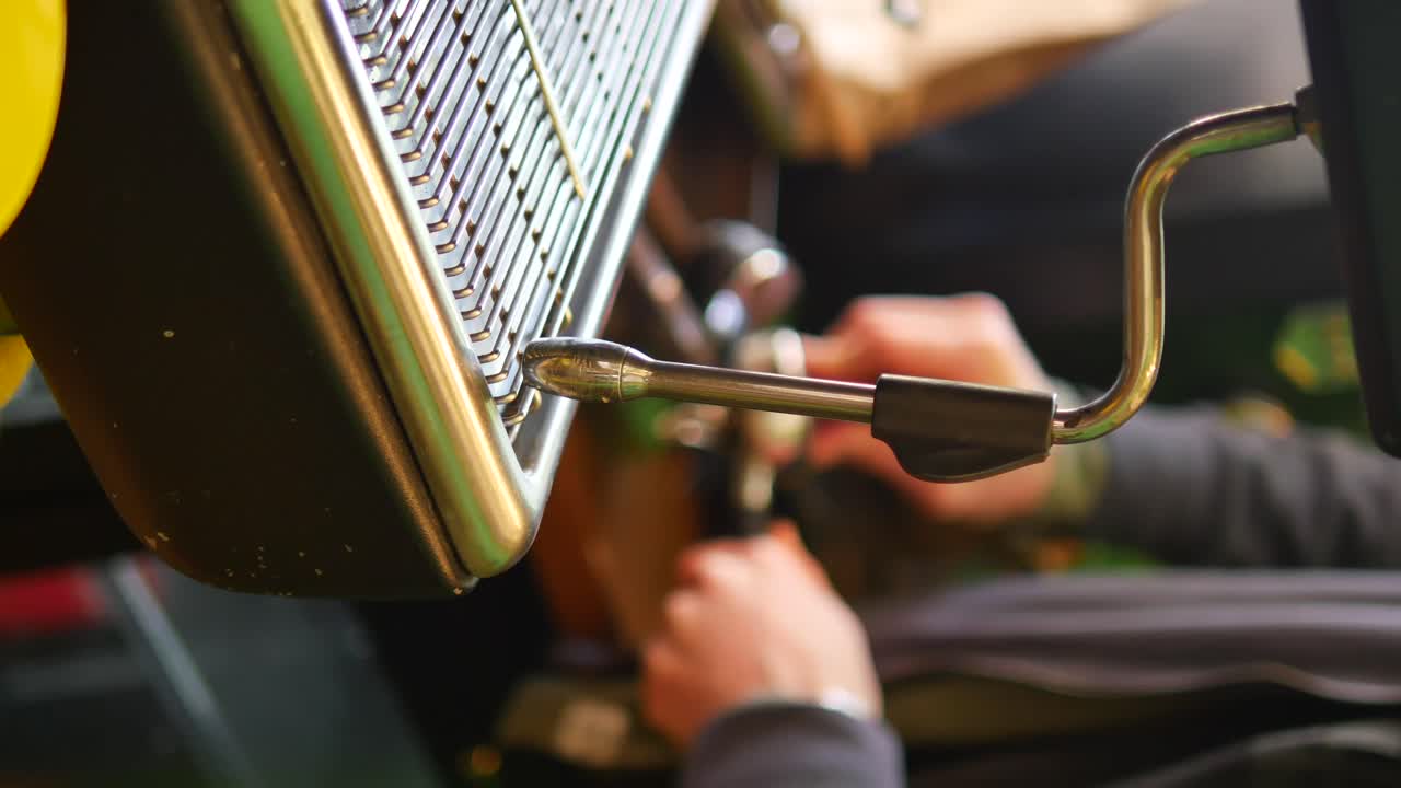 Close-up of a tractor lever and hand