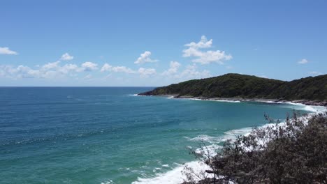 Drone-fast-ascending-showing-a-tropical-beach-and-peninsula