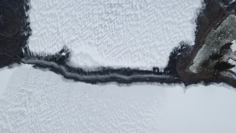 High-angle-bird's-eye-view-of-snowy-lake-with-thin-water-way-of-the-Suwalk-Gap-Masuria-Poland