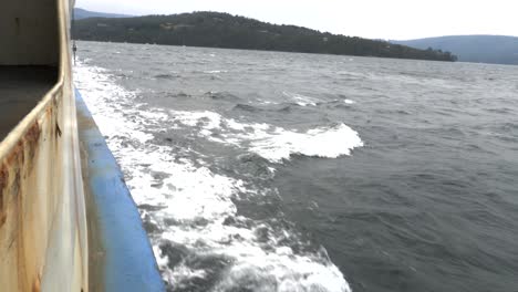 lado del ferry oxidado con salpicaduras de agua blanca durante el día cambiante, tasmania, australia