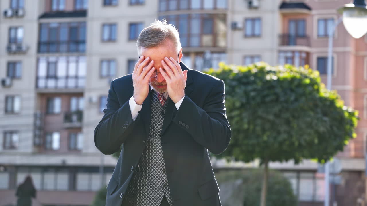 Mature businessman telling something on the camera outdoors. Portrait of a middle aged man in suit and tie talking in the street gesticulating a lot.