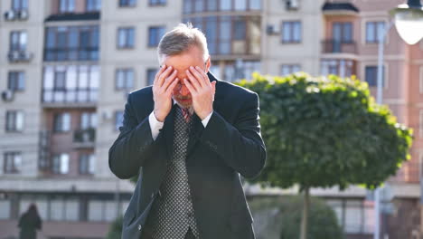 mature businessman telling something on the camera outdoors. portrait of a middle aged man in suit and tie talking in the street gesticulating a lot.