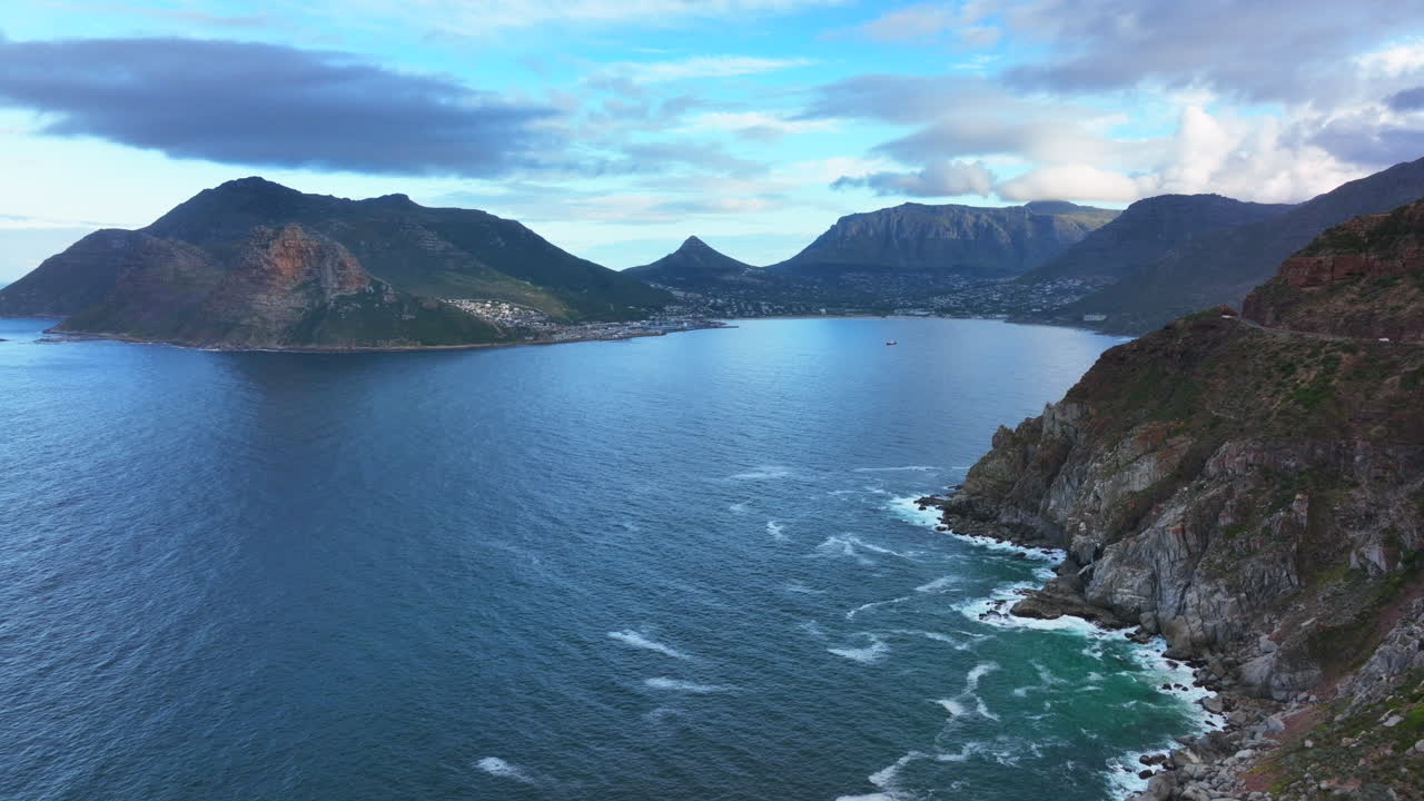 Chapman Peak South Africa sunset drive aerial cinematic drone Hout Bay marina Cape Town Fish Hoek Good Hope Simon's Town waves crashing rugged coast aqua deep blue water lush greenery summer forward