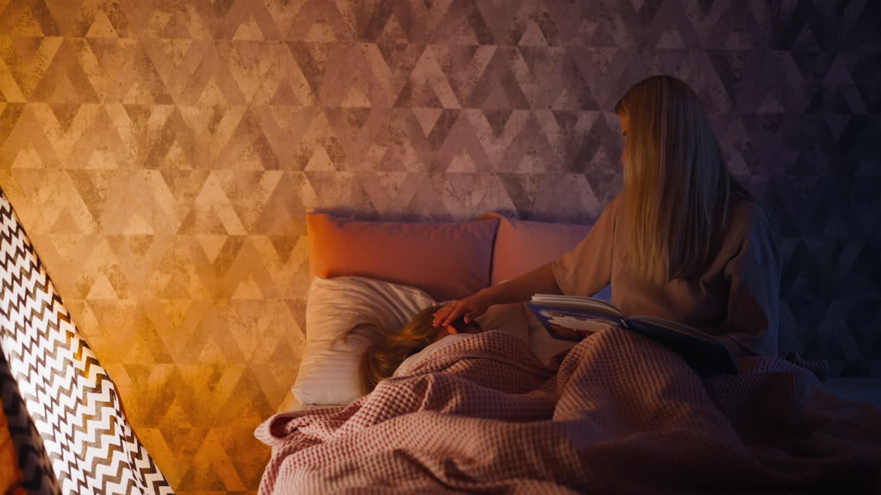 책 스트로크를 가진 여자 집에서 침대에 잠자는 아이