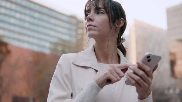 Mujer joven usando smartphone en un entorno urbano