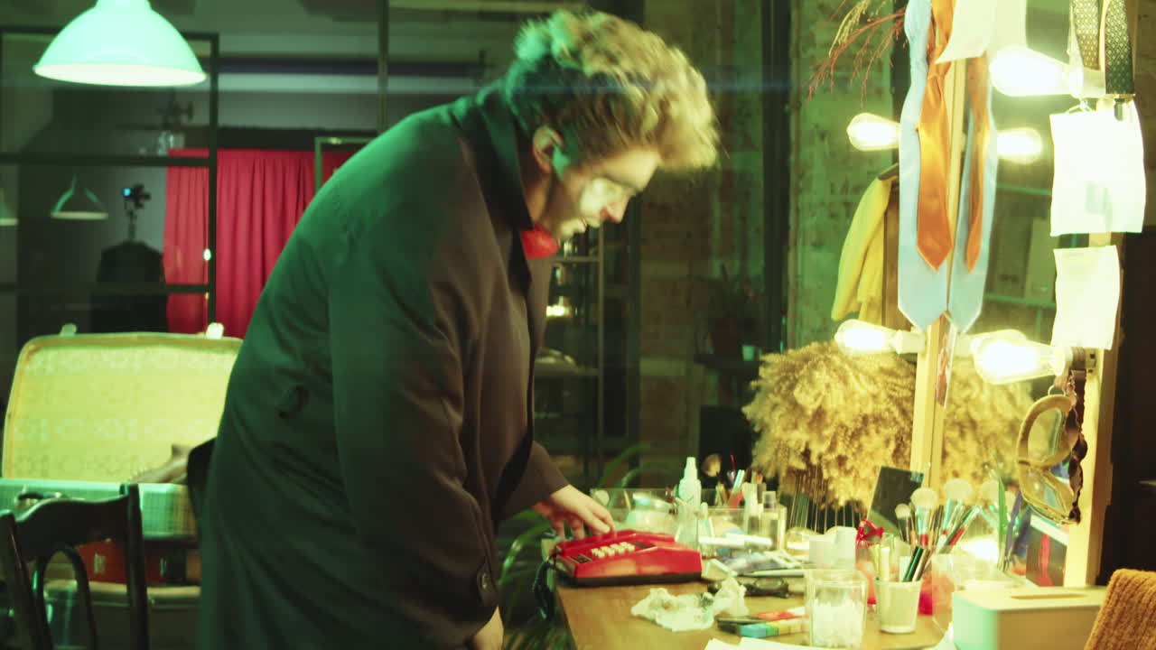 남자 조롱거리가 드레싱 에서 전화로 이야기하고 있다