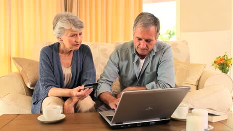 una pareja de ancianos tratando de comprar algo en internet