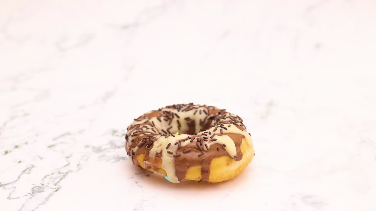 deliciosas rosquillas con chocolate blanco y negro esmaltado giran en círculo - detenga el movimiento