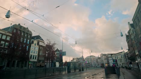 morning view of rokin in amsterdam featuring tram lines, historic and modern architecture, and a pastel sky. quiet urban street reflects the city's charm and cultural essence. amsterdam, nederland