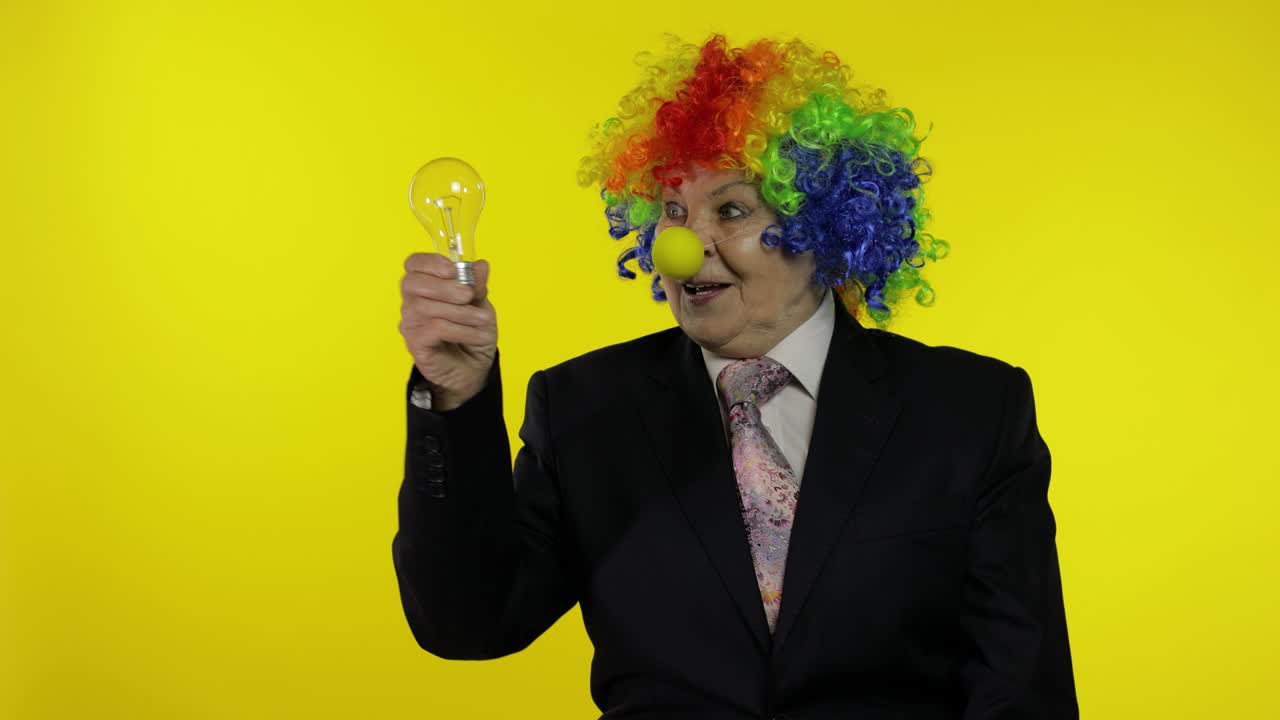 anciana mujer de negocios payaso en peluca espectáculo bombilla. se le ocurrió una gran idea