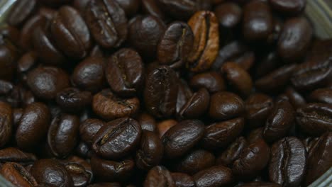 very close footage of coffee beans in a jar, roasted, zoomed out