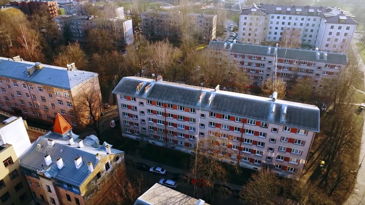 Golden spring sunlight illuminates Riga’s old apartments and nearby bare trees